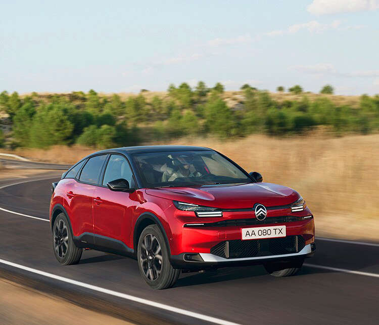 Червоний Citroën C4 їде по трасі за містом